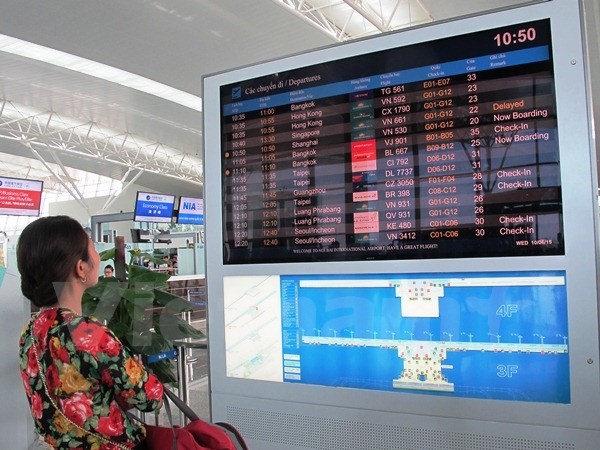 Hành khách xem hệ thống bảng điện tử chuyến bay tại sân bay Nội Bài. (Ảnh: Việt Hùng/Vietnam+)