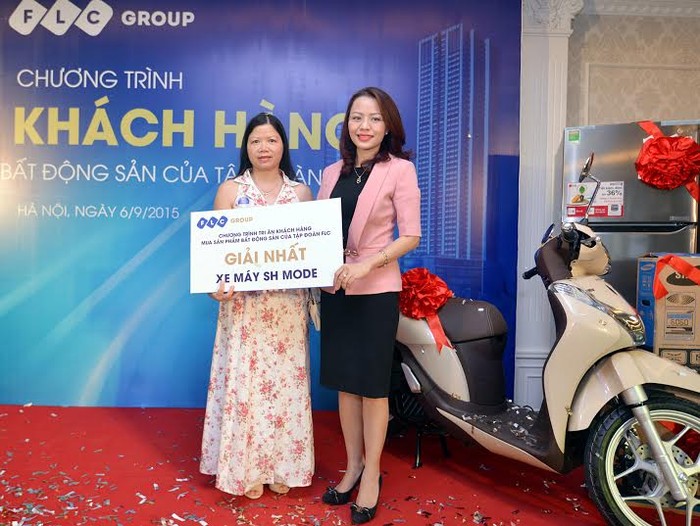 Bà Hương Trần Kiều Dung, Tổng giám đốc Tập đoàn FLC (phải) trao quà tặng may mắn là xe máy SH Mode cho khách hàng.