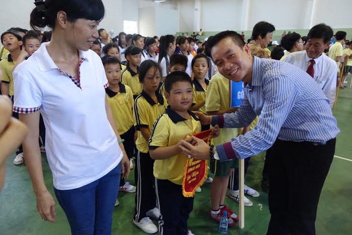 Ông Trương Văn Toàn, Giám đốc Đối ngoại &amp; Pháp lý trao cờ lưu niệm cho các học sinh tham gia Ngày Hội thể thao học sinh khuyết tật TP.HCM lần V năm 2016.