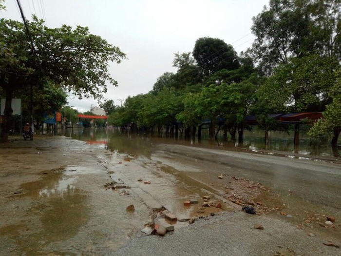 Nước lũ đang dâng lên chia cắt con đường vào thị trấn Hương Khê. Ảnh: Lê Văn Vỵ.