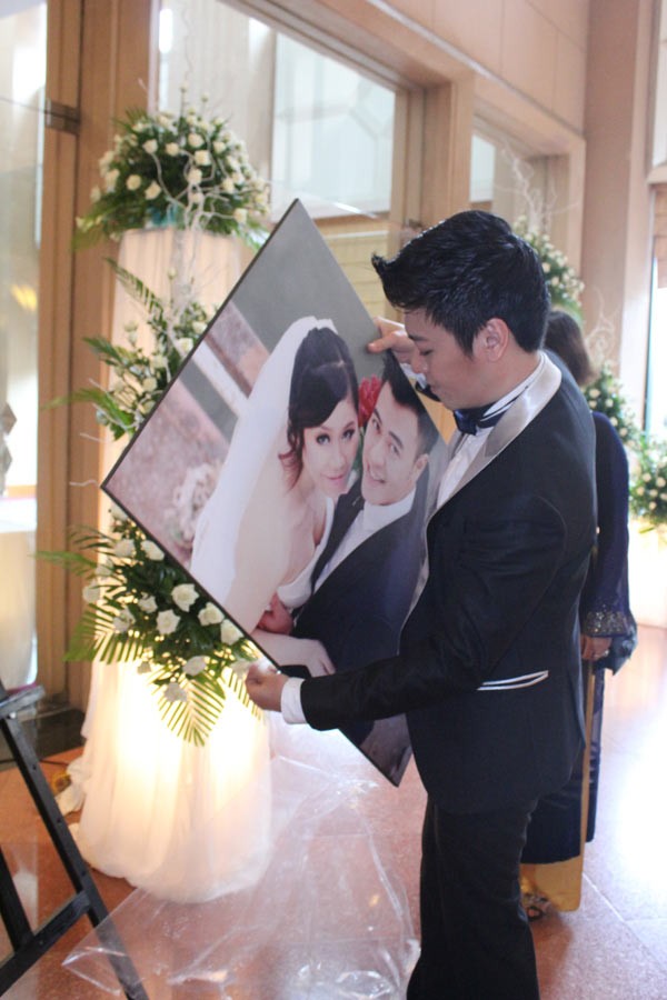 Trước khi lễ cưới bắt đầu, ca sĩ Phan Anh - anh trai của Tuấn Tú - là người chính tay treo ảnh cưới của em trai trước phòng tiệc.