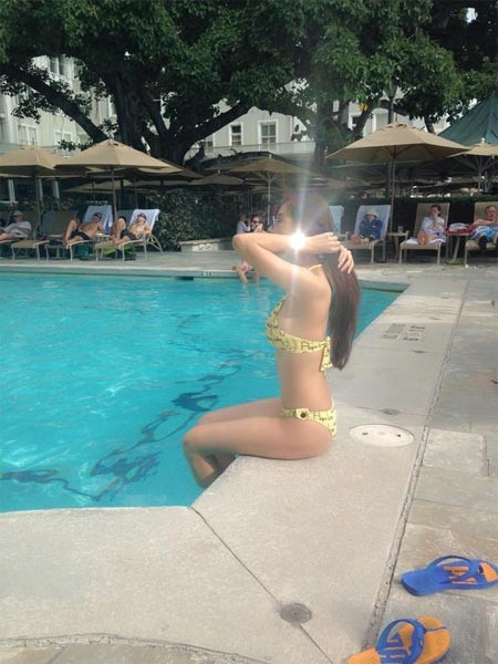 Hoa hậu mải mê ngồi tạo dáng bên bể bơi