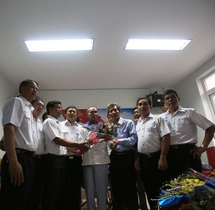Ông Đặng Công Ngữ (thứ ba từ phải sang) - nguyên Chủ tịch UBND huyện Hoàng Sa tặng hoa cho các cựu binh Gạc Ma. (Ảnh: An Nguyên)