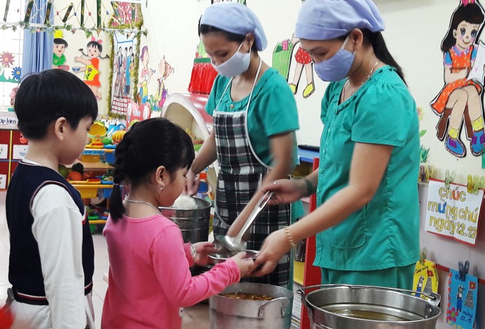 Các cô cấp dưỡng phải bảo đảm các điều kiện về vệ sinh cho trẻ trong bữa ăn. (Ảnh chụp tại một bữa ăn của trẻ trường mầm non Cẩm Nhung, Đà Nẵng)