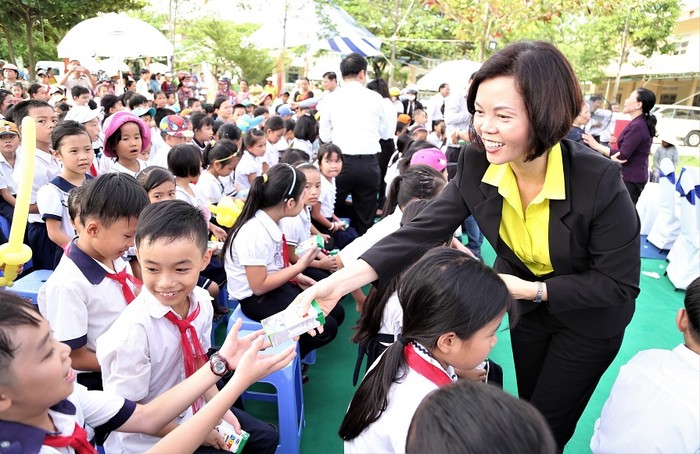 Bà Bùi Thị Hương – Giám đốc Điều hành Vinamilk trao sữa cho các em học sinh.