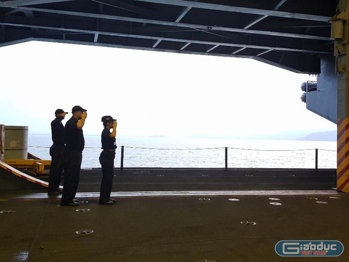 Ba thủy thủ trên tàu sân bay thực hiện nghi lễ chào khách kiểu nhà binh.