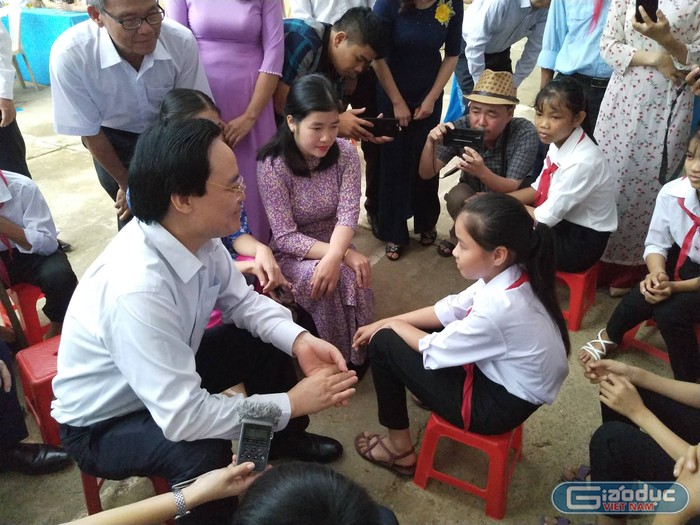 Bộ trưởng Phùng Xuân Nhạ động viên học sinh vùng rốn lũ vượt qua khó khăn để học tốt.