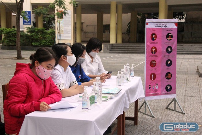 Các giáo viên Trường trung học phổ thông Trần Phú trực ngay tại cổng trường cùng các thiết bị đo thân nhiệt, nước sát khuẩn.
