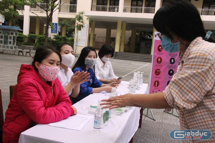Học sinh được hướng dẫn cách sử dụng nước sát khuẩn trước khi vào trường.