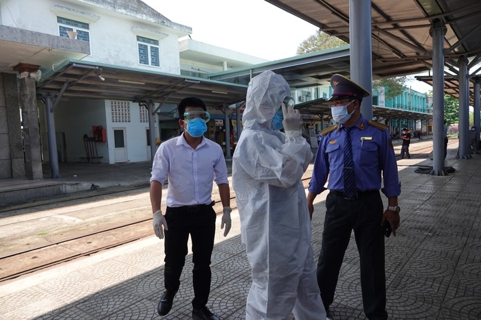 Cơ quan chức năng thực hiện cách ly bốn du khách đi cùng chuyến bay với bệnh nhân nhiễm Covid-19 thứ 17 khi tàu đến ga Đà Nẵng. Ảnh: AD
