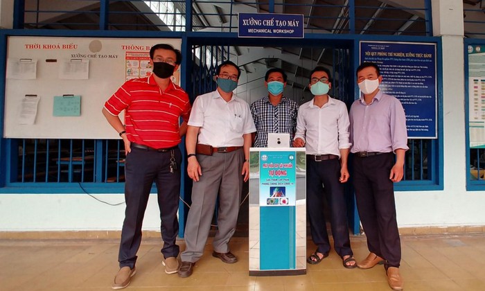 Nhóm giảng viên Trường Đại học Sư phạm Kỹ thuật Đà Nẵng bên cạnh sản phẩm máy rửa tay sát khuẩn tự động. Ảnh: HT