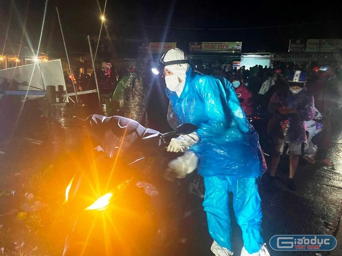 Các thành viên đội SOS không quản ngại mưa gió, đêm khuya sẵn sàng hỗ trợ người dân sửa chữa xe máy trên chặng hành trình về quê tránh dịch. Ảnh&quot; AN