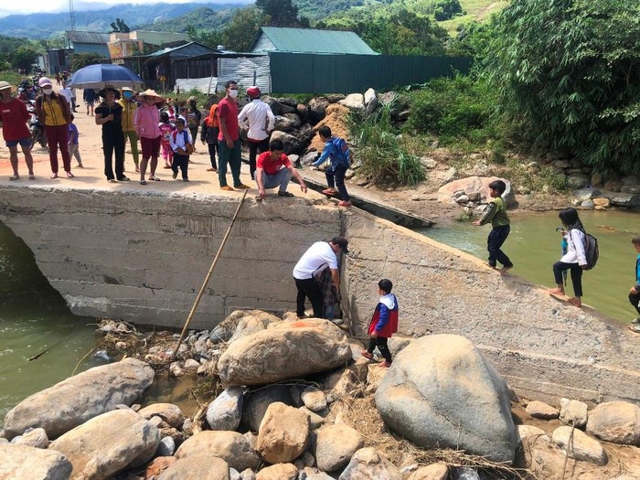 Các thầy giáo Trường tiểu học Mường Hoong phải bế học sinh qua đoạn cầu bị hỏng. Ảnh: CTV