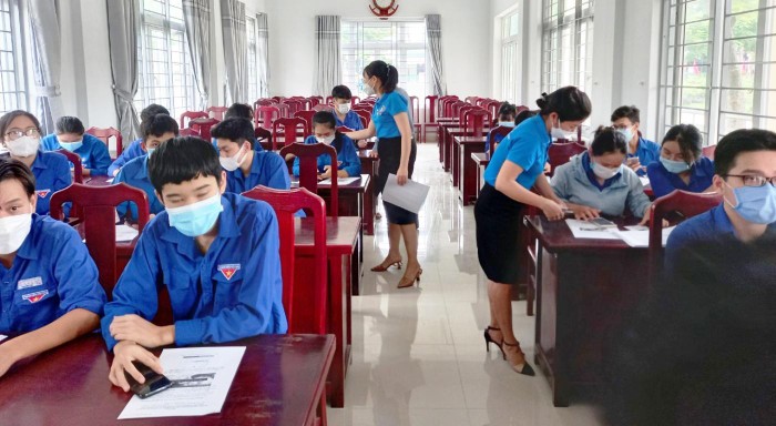 Cán bộ bảo hiểm xã hội Quảng Nam hướng dẫn học sinh, sinh viên cài đặt ứng dụng VssID. Ảnh: AN