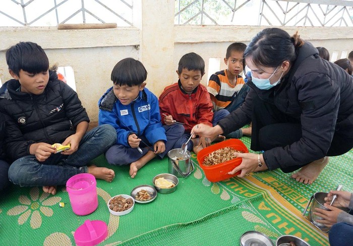 Cô Hoa chia phần thức ăn do các thầy cô, mạnh thường quân hỗ trợ cho các em học sinh ở điểm trường Kon Du sau khi bị ngắt chế độ hỗ trợ bán trú theo Nghị định 116. Ảnh: MT