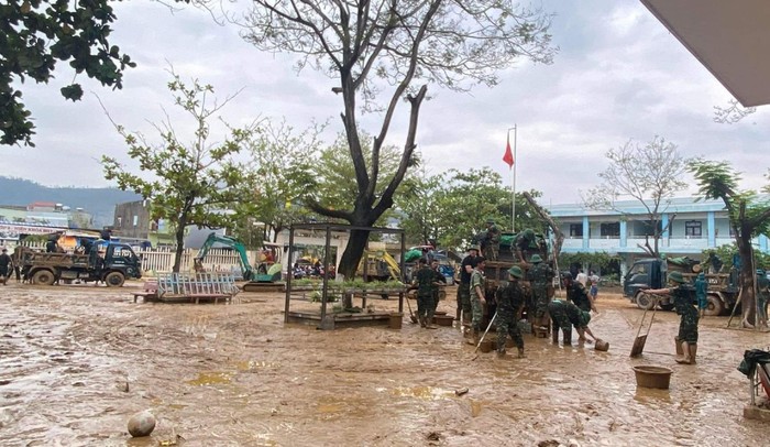 Lực lượng quân đội, công an hỗ trợ các thầy cô Trường tiểu học Hồng Quang (quận Liên Chiểu) dọn dẹp bùn sau khi nước lũ vừa rút.