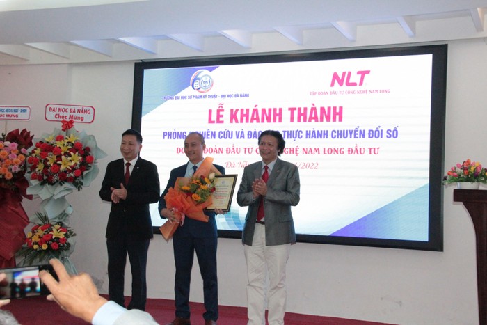 Phó Giáo sư Phan Cao Thọ - Hiệu trưởng Trường Đại học Sư phạm Kỹ thuật Đà Nẵng (ngoài cùng bên phải) cùng lãnh đạo Đại học Đà Nẵng trao hoa và giấy chứng nhận đầu tư cho lãnh đạo Tập đoàn NLT Group. Ảnh: AN