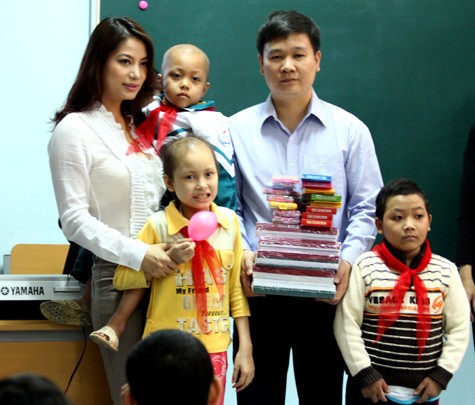 Nhà báo Nguyễn Tiến Bình thay mặt các em học sinh nhận quà từ diễn viên Trương Ngọc Ánh