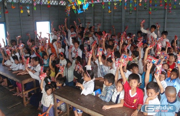 Phụ huynh và học sinh nhận quà tài trợ của khách du lịch đến từ Việt Nam.