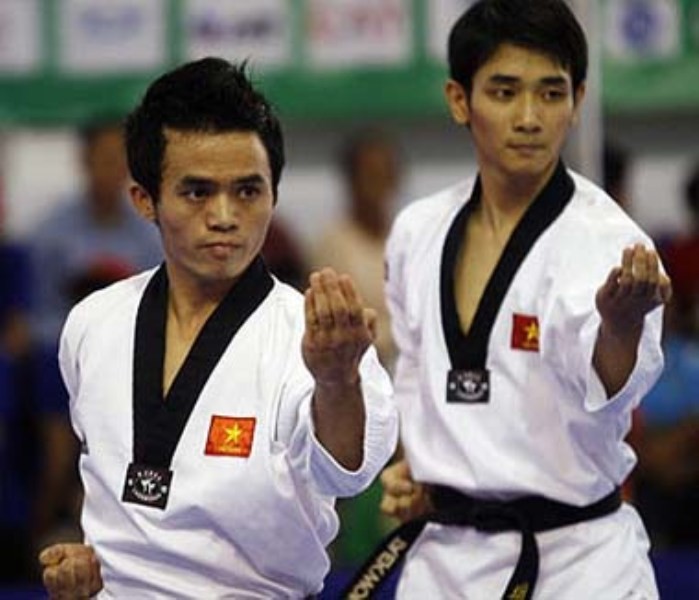 Thành Dương (phải) trong bài biểu diễn quyền đồng đội nam tại SEA Games 25 (năm 2009).